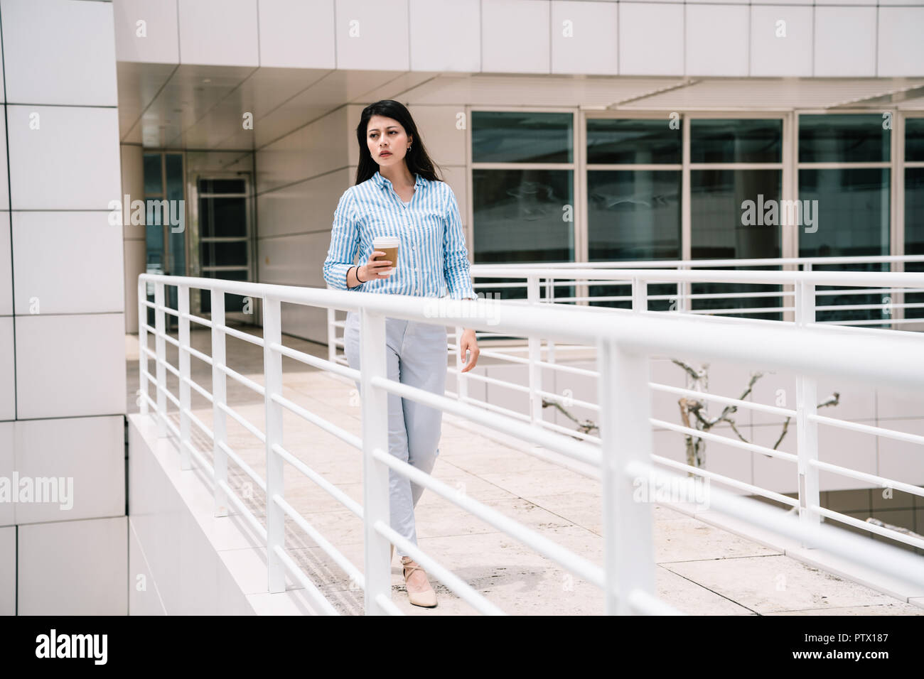 Une photo d'une dame élégante de marcher à travers le pont vers un autre bâtiment Banque D'Images