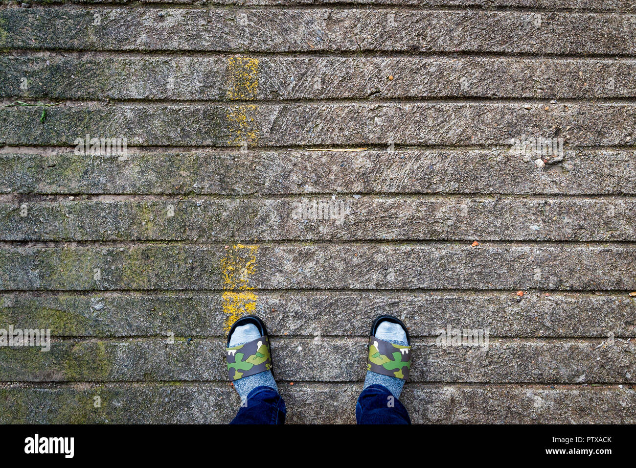 Socked pieds Slippered sur chaussée de pierre Banque D'Images