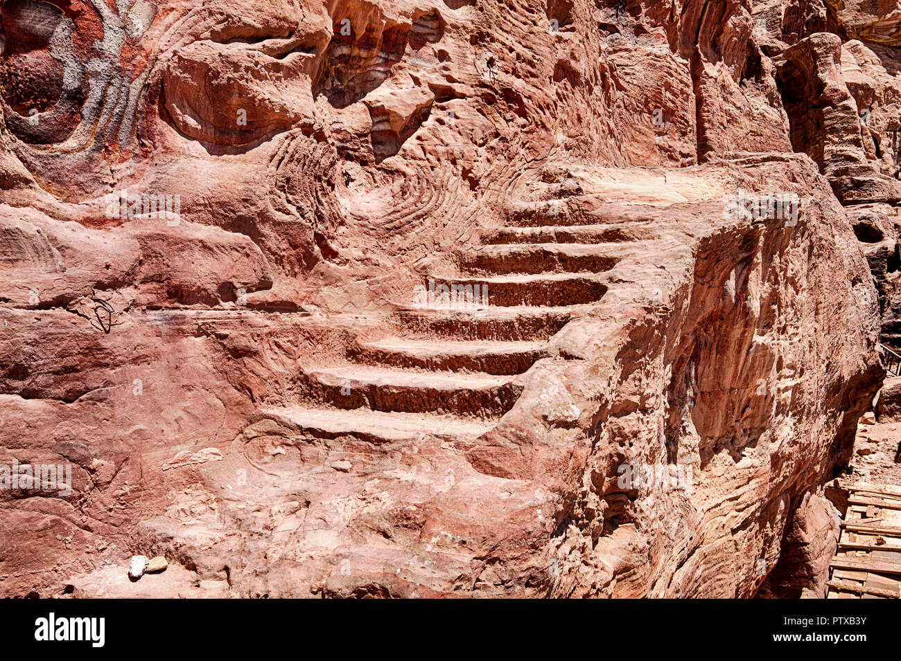 Une petite série de marches en pierre, comme un vieil escalier, mène le côté d'une falaise à l'Urne tombe sur l'edige de la ville antique de Petra dans le Sud Banque D'Images