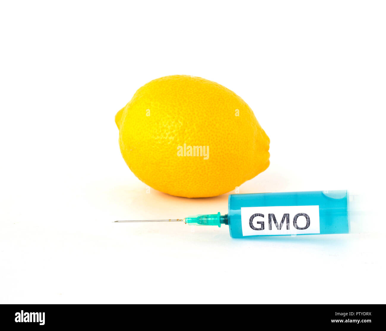 Citron sur fond blanc à côté de laquelle est une seringue d'OGM et de dérivés nitrés, close-up, organisme génétiquement modifié Banque D'Images