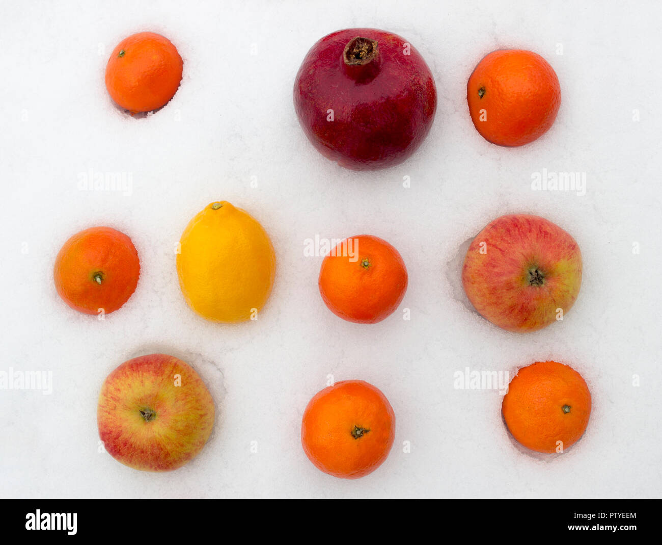 Les fruits sur la neige, la mandarine, citron, pomme, grenade Banque D'Images