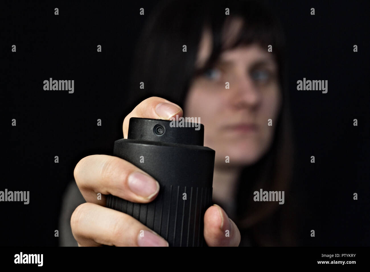 Fille avec un gaz, le gaz poivré, close-up, fond noir Banque D'Images