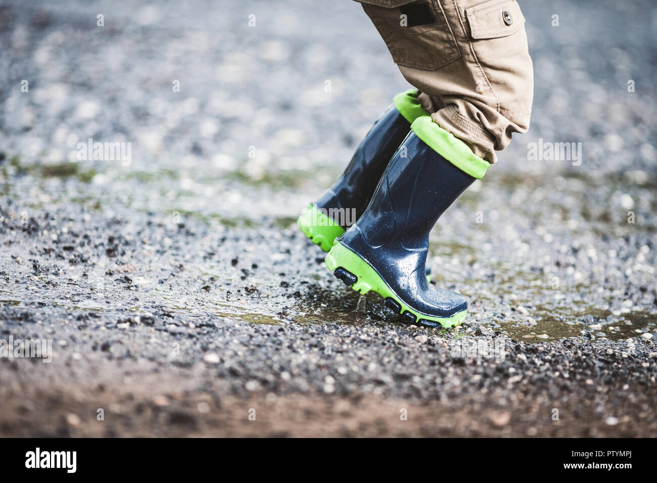 Close up sur l'enfant en portant des bottes en caoutchouc par temps de pluie Banque D'Images