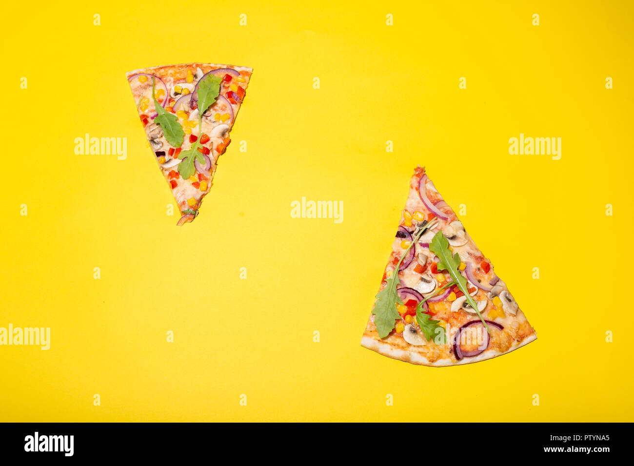 Deux tranches de pizza mis sur fond jaune. Banque D'Images