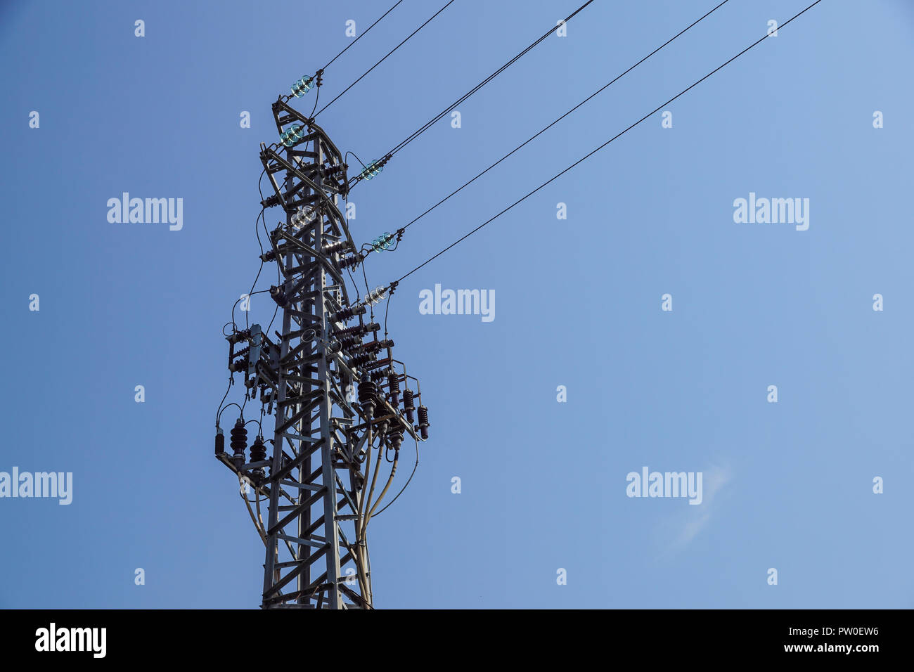 Tour en acier de type treillis sur des fragments de ciel bleu comme une partie de la ligne à haute tension. Détails ligne électrique aérienne Banque D'Images