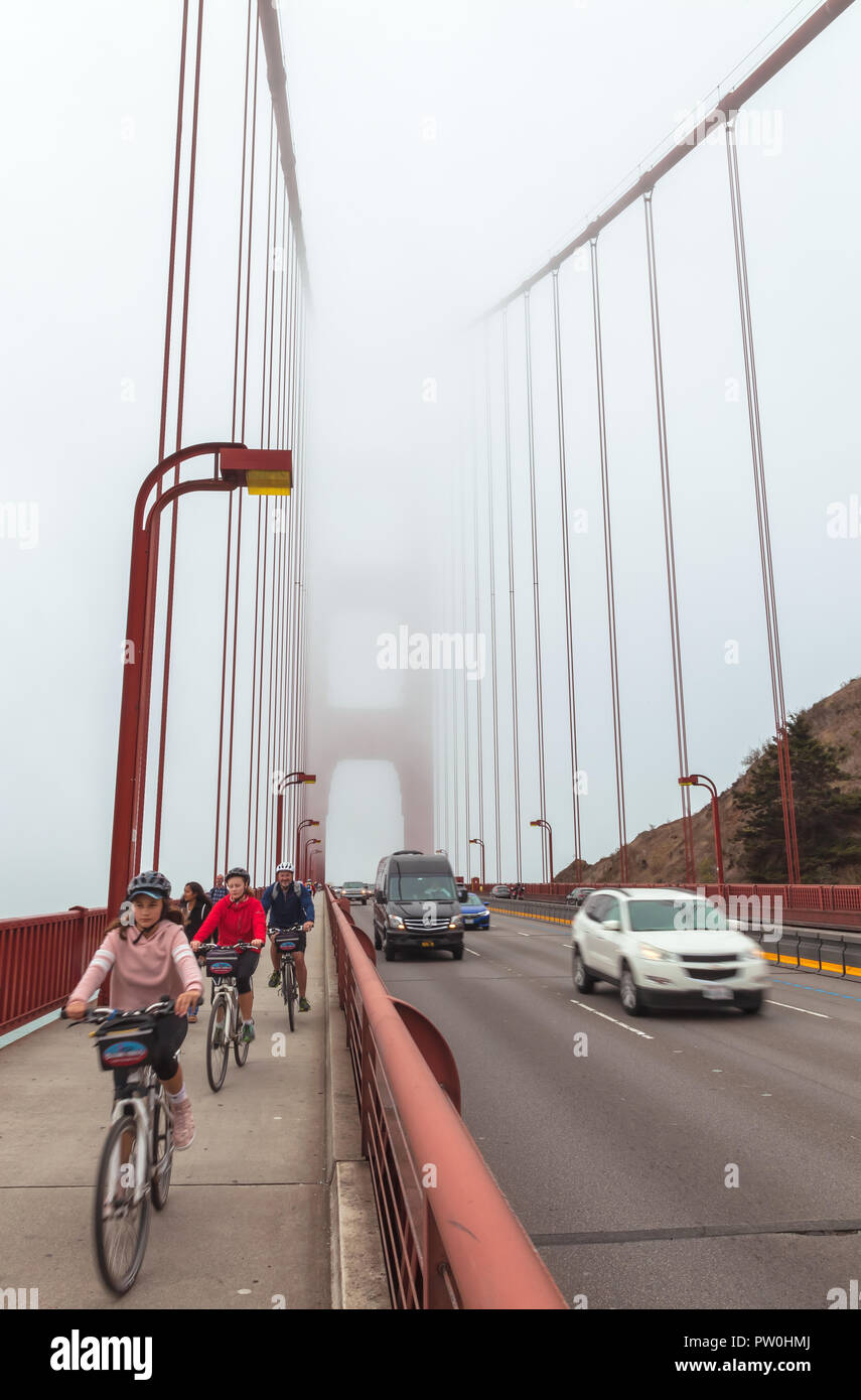 Les cyclistes et le trafic sur le Golden Gate Bridge San Francisco, California, United States, sur un fin brouillard matin d'été. Banque D'Images