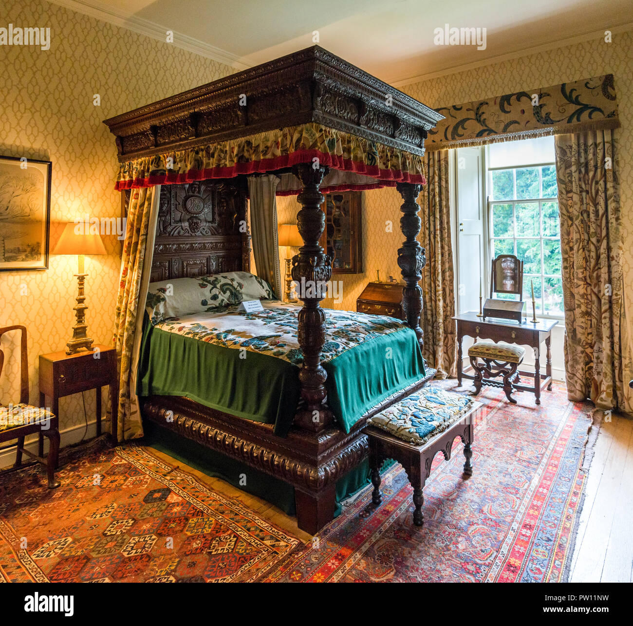 Un grand lit à baldaquin décoré par des piliers sculptés dans l'une des salles de l'intérieur du Château de Crathes, Aberdeenshire, Scotland Banque D'Images