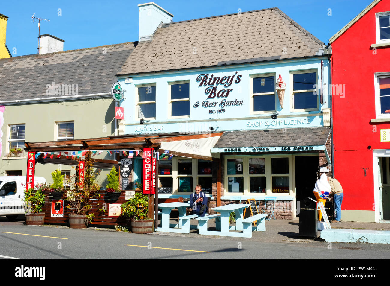 Les touristes de prendre un verre à l'extérieur d'un bar irlandais traditionnel, Sneem, comté de Kerry - John Gollop Banque D'Images