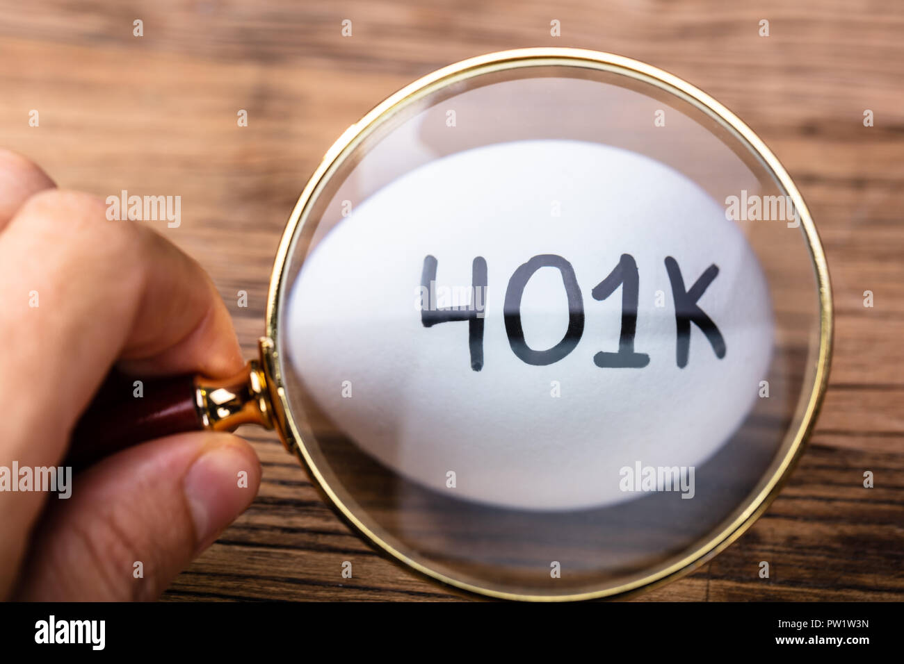 L'examen d'une personne d'Œufs blancs 401k avec loupe Banque D'Images