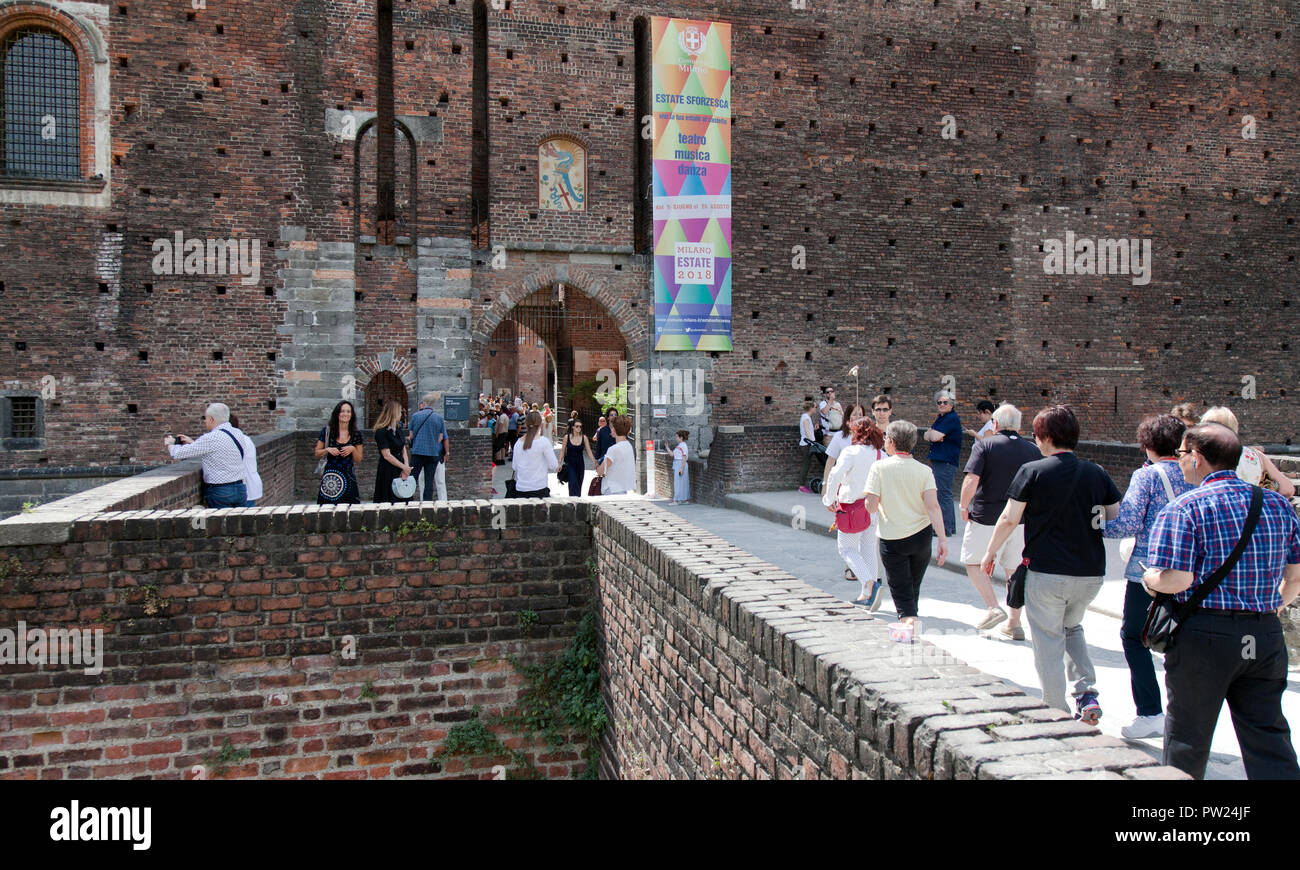Les gens qui entrent dans l'une des portes sur l'ancien fossé à Milan, le château des Sforza (Italien : Castello Sforzesco). Il a été construit au 15ème siècle par Franc Banque D'Images