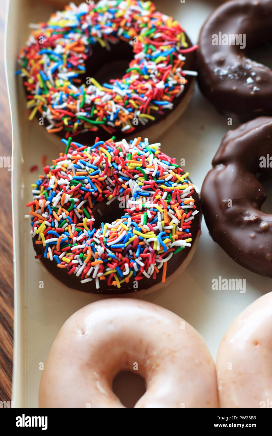 Sprinkles multicolores sur le chocolat de beignes Krispy Kreme Banque D'Images