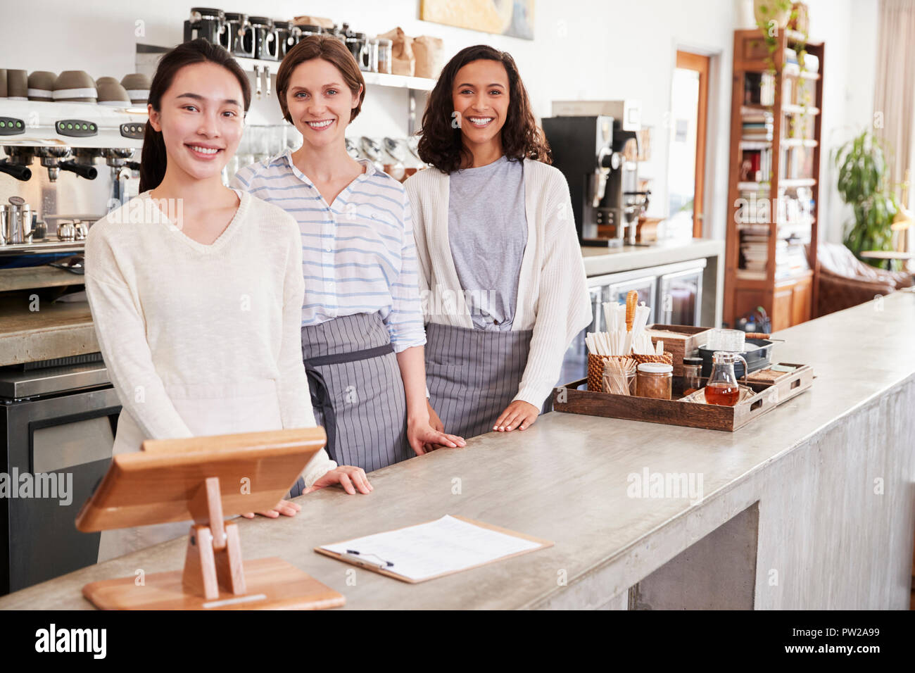 Trois femmes propriétaires de café debout derrière le comptoir Banque D'Images