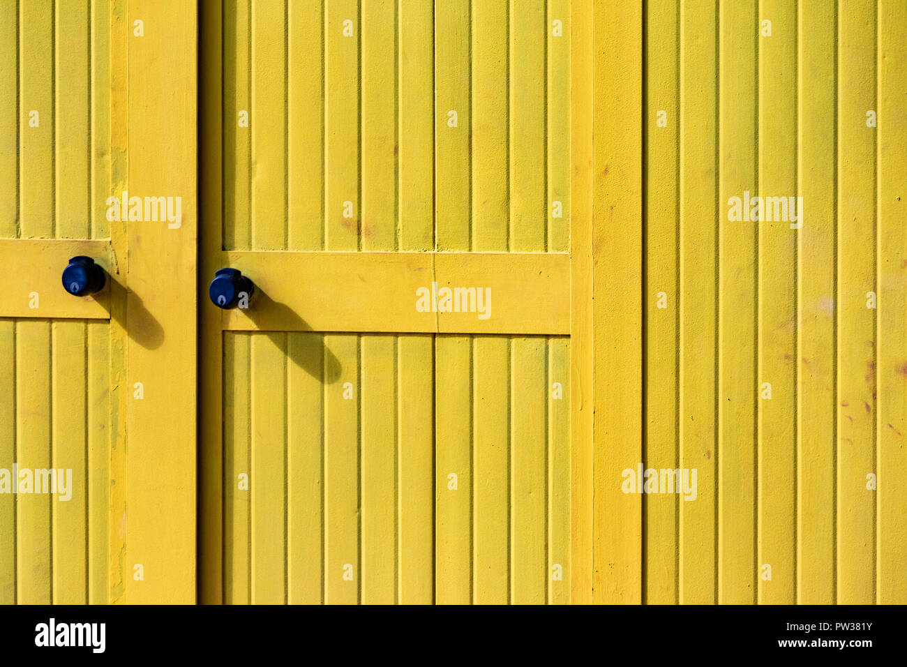 Belles maisons de bain jaune sur la plage de sable. Abris vides sur une journée ensoleillée mais Moody. Architecture balnéaire, peinture colorée, labyrinthe de labyrint. Banque D'Images