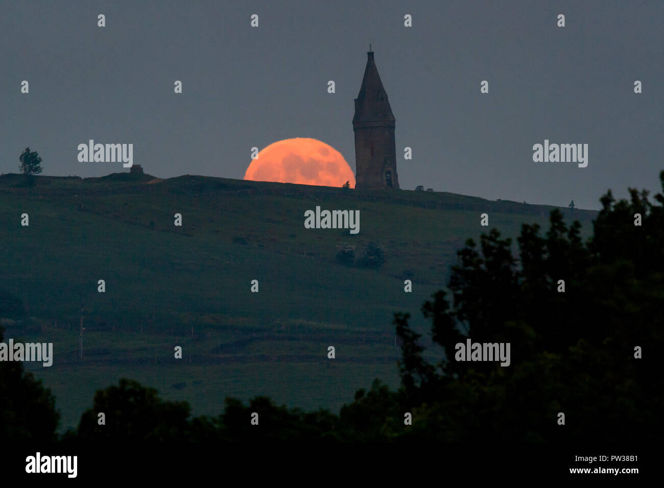 La pleine lune, connue en mai que la fleur de lune, s'élève au-dessus de Hartshead Pike près de Ashton-Under-Lyne Banque D'Images