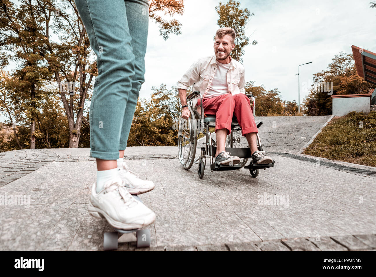 Mobilité homme assis en fauteuil roulant et à la recherche au conseil penny Banque D'Images