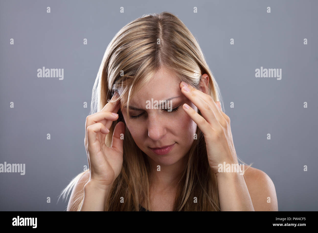 O Photo blonde jeune femme souffrant de maux de tête Banque D'Images