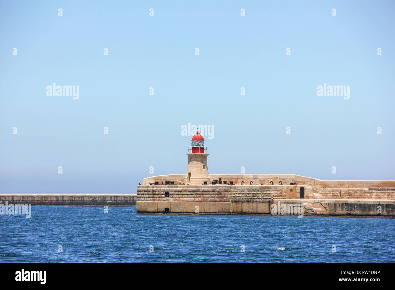 Phare rouge dans le Grand Port de La Valette avec Deep blue mer calme Banque D'Images