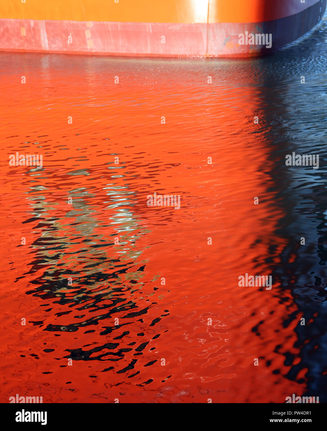 Gros plan du navire avec des réflexions de coque rouge dans l'eau Banque D'Images