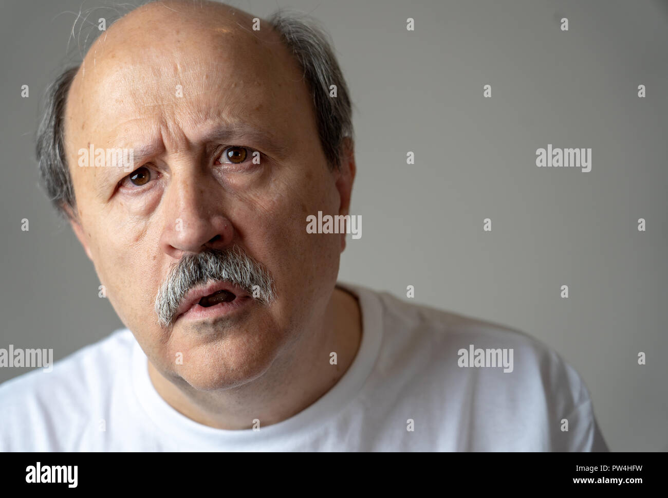 Close up portrait of senior man looking confus et perdu souffrant de démence, perte de mémoire ou de la maladie d en santé mentale chez les adultes plus âgés et plus tard Banque D'Images