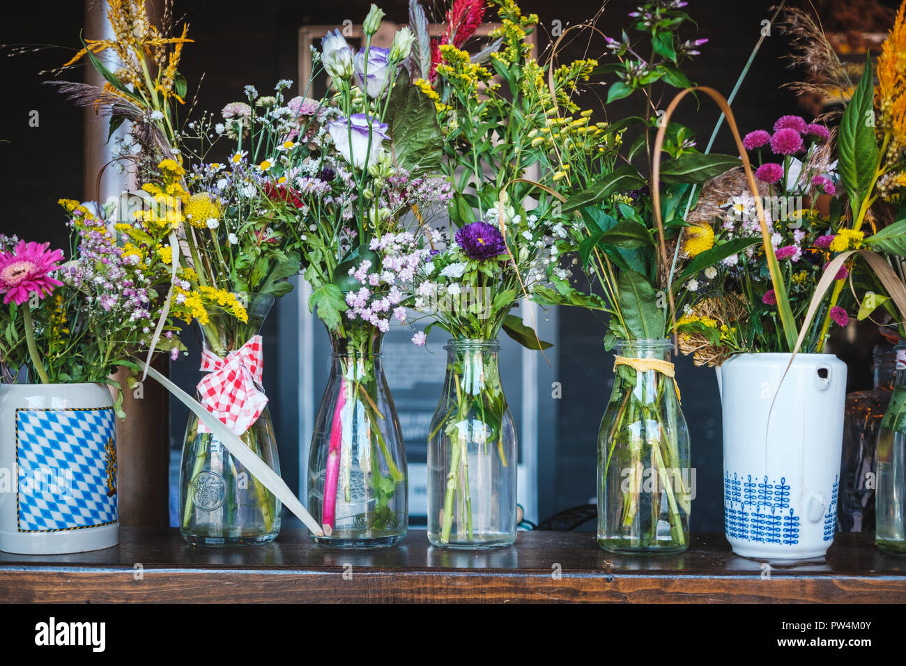 Bouquet de fleurs dans un vase à fleurs - bouquets, dans les verres sur la table - compteur Banque D'Images