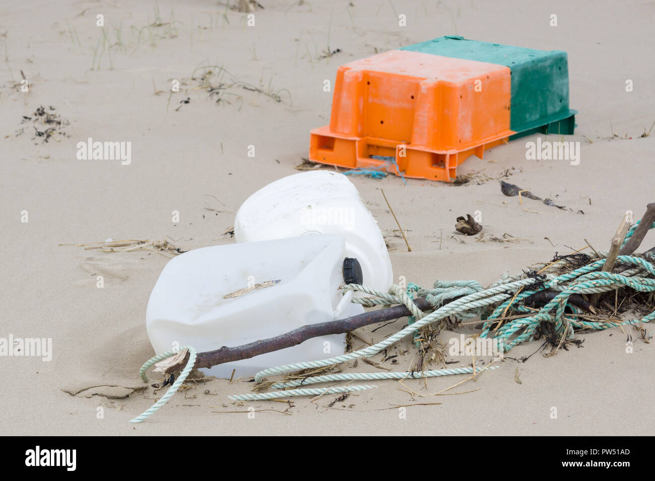 Le plastique déchets rejetés sur une plage et la partie enterrée dans le sable d'un exemple des nombreux morceaux d'ordures dans les océans du monde entier Banque D'Images