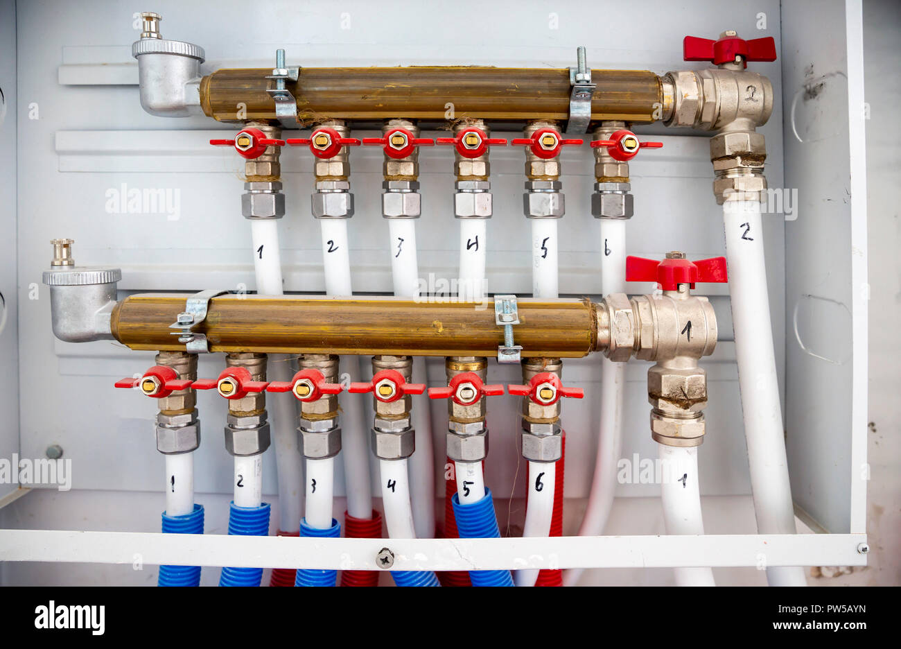 Les tuyaux du système de chauffage central. Tubes de liaison blanc le  chauffage et l'eau chaude de la maison. Soupapes rouge Photo Stock - Alamy