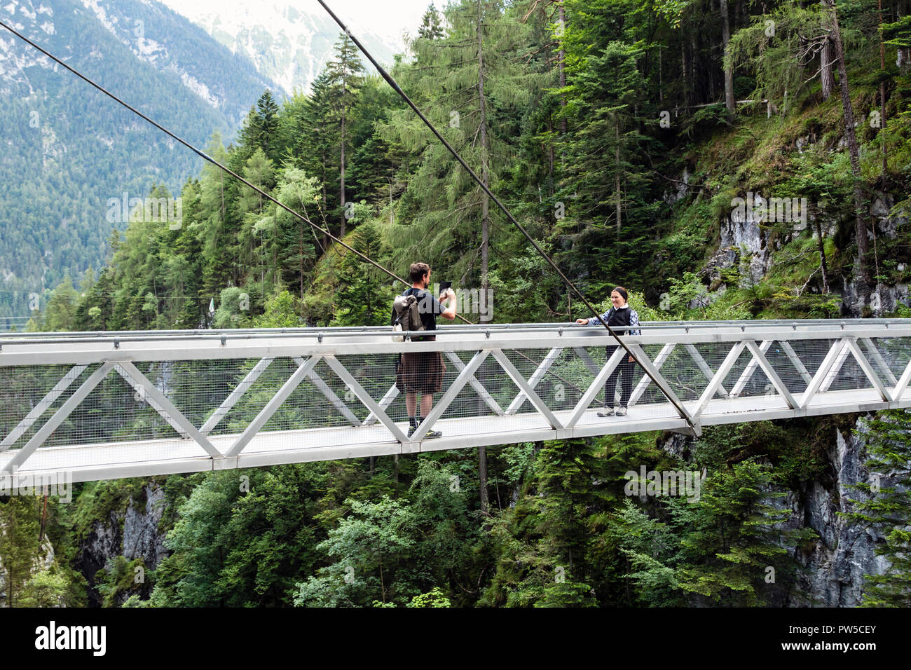 Les touristes de prendre une photo sur le pont suspendu au-dessus de la Gorge de Leutasch, Autriche Banque D'Images Les touristes de prendre une photo sur le pont suspendu au-dessus de la Gorge de Leutasch, Autriche Banque D'Images