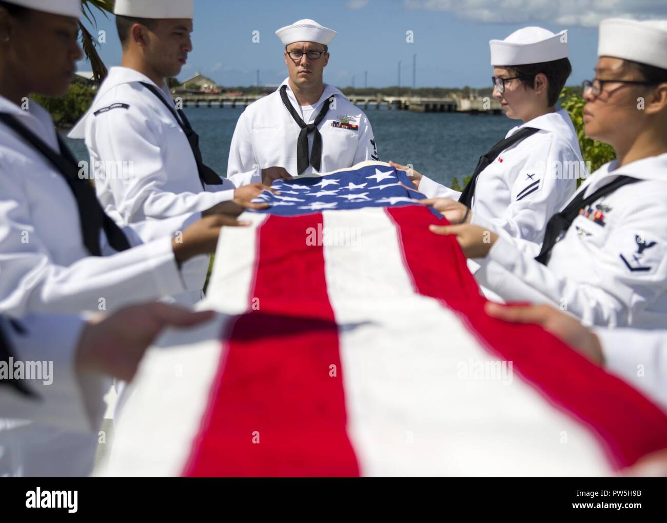 PEARL HARBOR (19 septembre 2017) marins affectés à la Garde de cérémonie de récompenses et de l'unité de base commune (JBPHH Harbor-Hickam Pearl) plier le drapeau national au cours d'une cérémonie de dispersion de cendres pour Pearl Harbour en chef de la Marine américaine survivant Mate du machiniste à l'USS Melvin Stone Memorial Utah sur Ford Island, JBPHH. Pierre a été stationné à bord du destroyer USS offres Dobbin (AD-3) au cours de la 1941 attaques Japonais sur Pearl Harbor. Ses cendres rejoint le reste des marins encore à bord USS Utah, qui a été coulé au cours de l'attaque de 1941. Banque D'Images