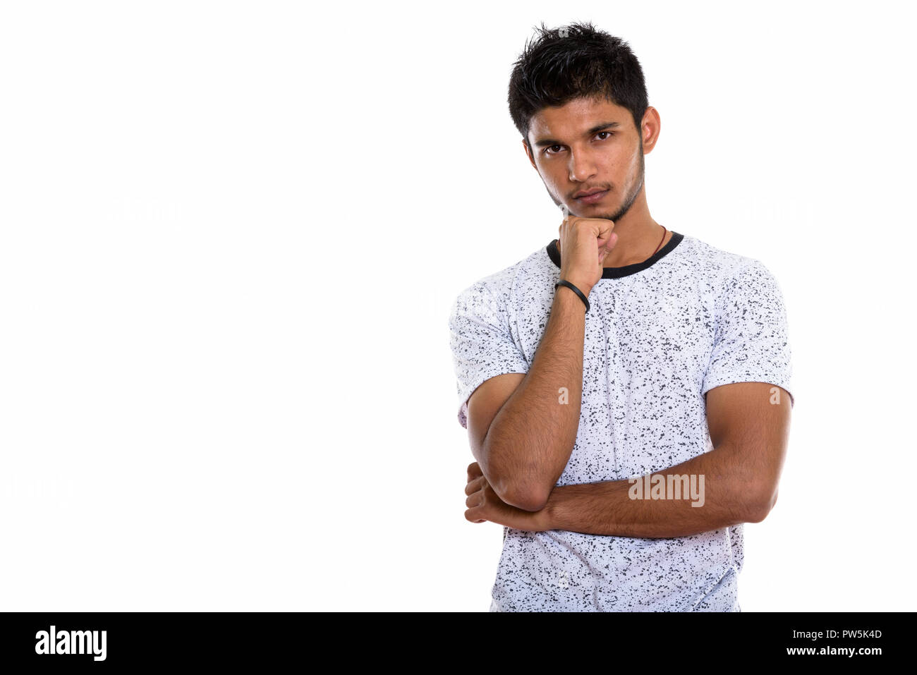 Studio shot of young handsome Indian man thinking Banque D'Images