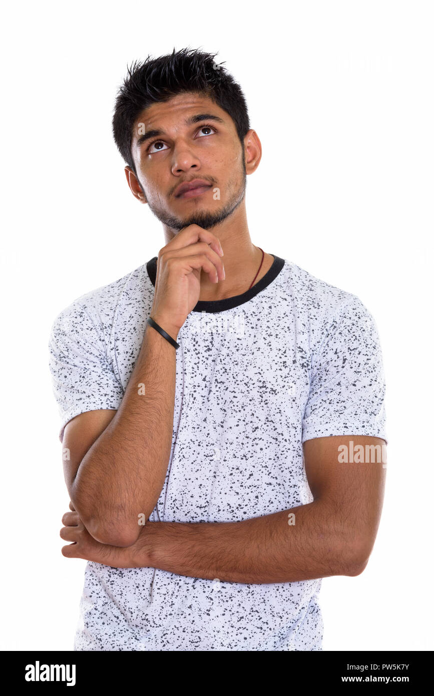 Studio shot of young handsome Indian man tout en pensant à la Banque D'Images