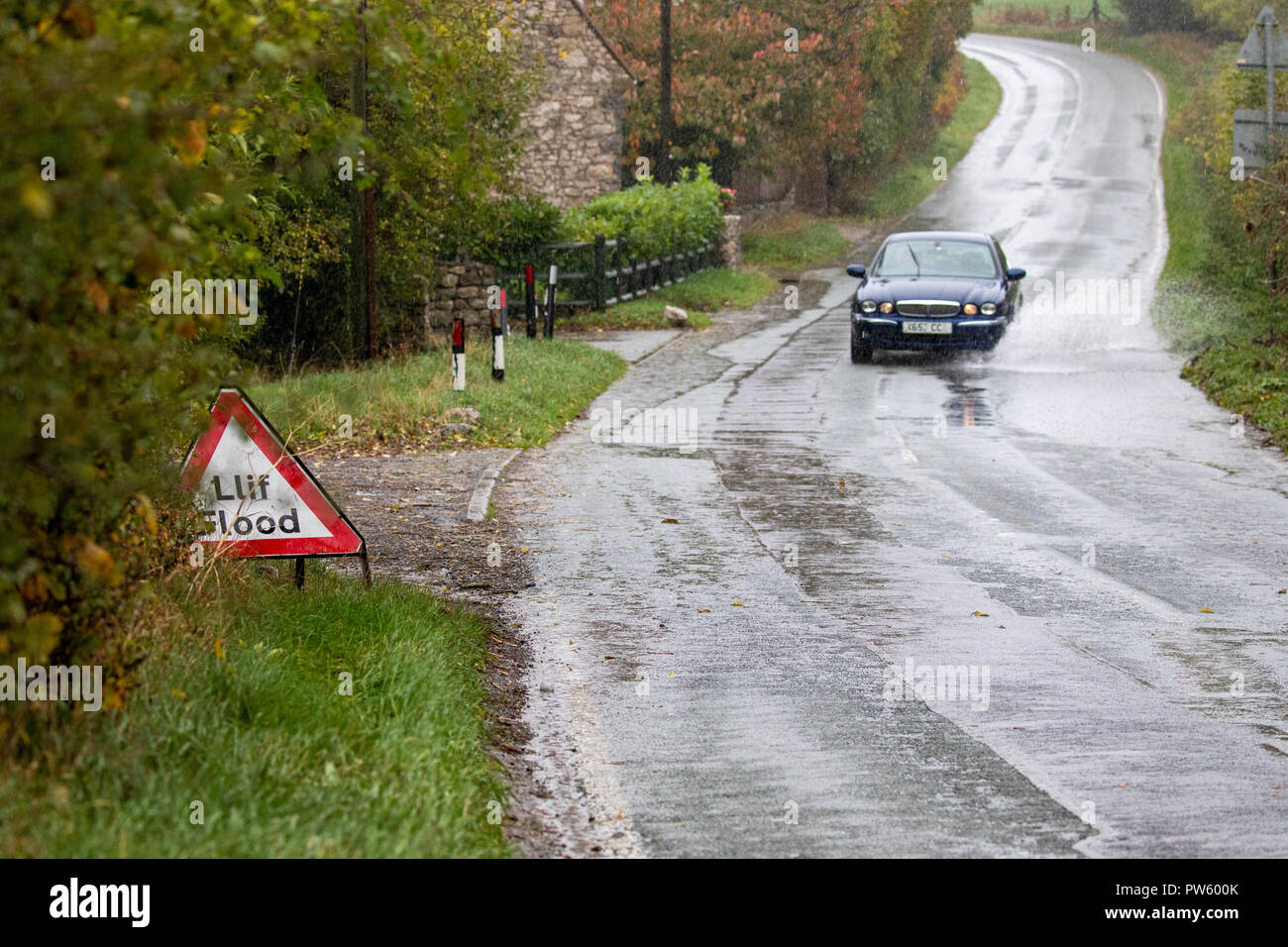 Flintshire, au nord du Pays de Galles, le 13 octobre 2018. Météo France : Fortes pluies pour aujourd'hui la plupart des avertissements météorologiques en place et des avertissements d'inondation pour les parties du pays de Galles. Une voiture roulant dans les eaux d'inondation le long d'un chemin rural près du village de Lixwm DGDImages, Flintshire ©/AlamyNews Banque D'Images
