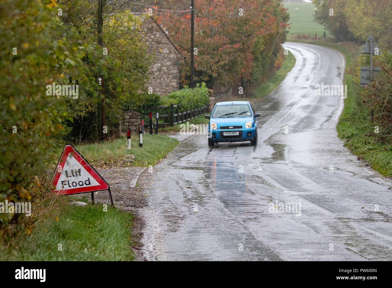 Flintshire, au nord du Pays de Galles, le 13 octobre 2018. Météo France : Fortes pluies pour aujourd'hui la plupart des avertissements météorologiques en place et des avertissements d'inondation pour les parties du pays de Galles. Une voiture roulant sur le mauvais côté de la route pour esquiver les eaux d'inondation le long d'un chemin rural près du village de Lixwm DGDImages, Flintshire ©/AlamyNews Banque D'Images