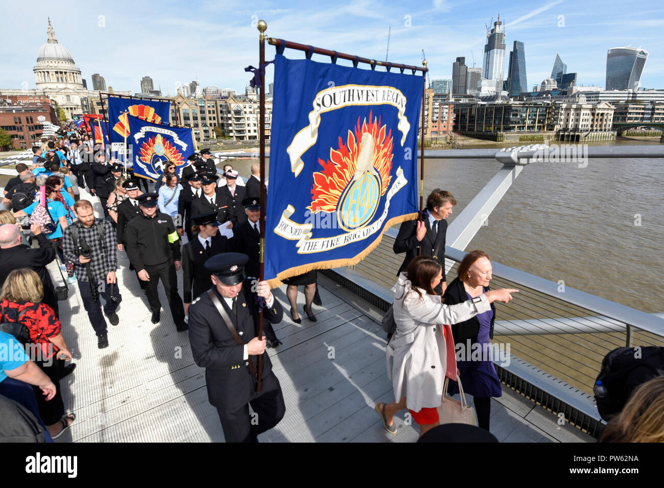 Londres, Royaume-Uni. 13 octobre 2018. Après une cérémonie de dépôt à l'échelle nationale à la mémoire des pompiers à côté de la Cathédrale St Paul, à la mémoire de pompiers morts représentant chaque service d'incendie au Royaume-Uni, les membres de l'Union européenne de lutte contre l'incendie (FBU) prendre part à un défilé officiel à travers le Millennium Bridge suivi d'un service à la cathédrale de Southwark pour commémorer le centenaire de la création de la FBU. Les activités sont les plus importantes jamais cérémonie pour les pompiers tués en service. Crédit : Stephen Chung / Alamy Live News Banque D'Images