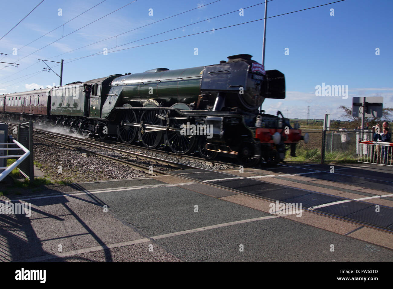 Ligne les amateurs de la route comme Flying Scotsman accélère le long de la côte Est de la ligne de messagerie au cours d'une excursion planifiée comme un mémorial à Alan Pegler, l'homme qui a sauvé la locomotive de la ferraille en 1963. Photographié ici ralentir après la section à Sutton de la banque où elle a obtenu le record de vitesse à 100 mph en 1934 et où au cours de l'exécution de memorial Alan Peglar's Ashes ont été commis à la chambre de combustion. Banque D'Images