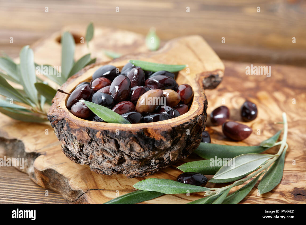 Brown Frais d'olives kalamata et de feuilles dans un bol en bois d'olivier Banque D'Images