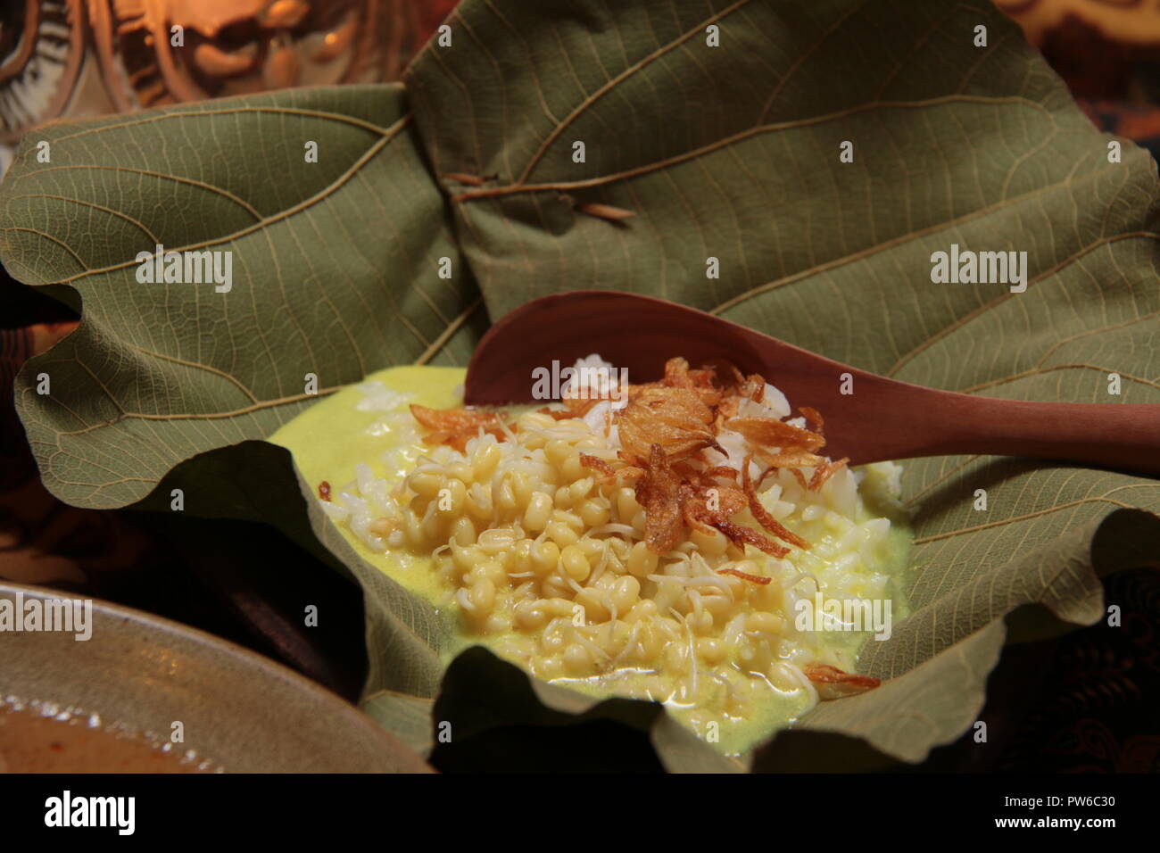 Opor Nasi ou Nasi Gulai, le riz dans la soupe de curry jaune, la populaire base de l'alimentation de Sate Blora. Servi dans un bol moyen, en authentique faite de feuilles de teck. Banque D'Images