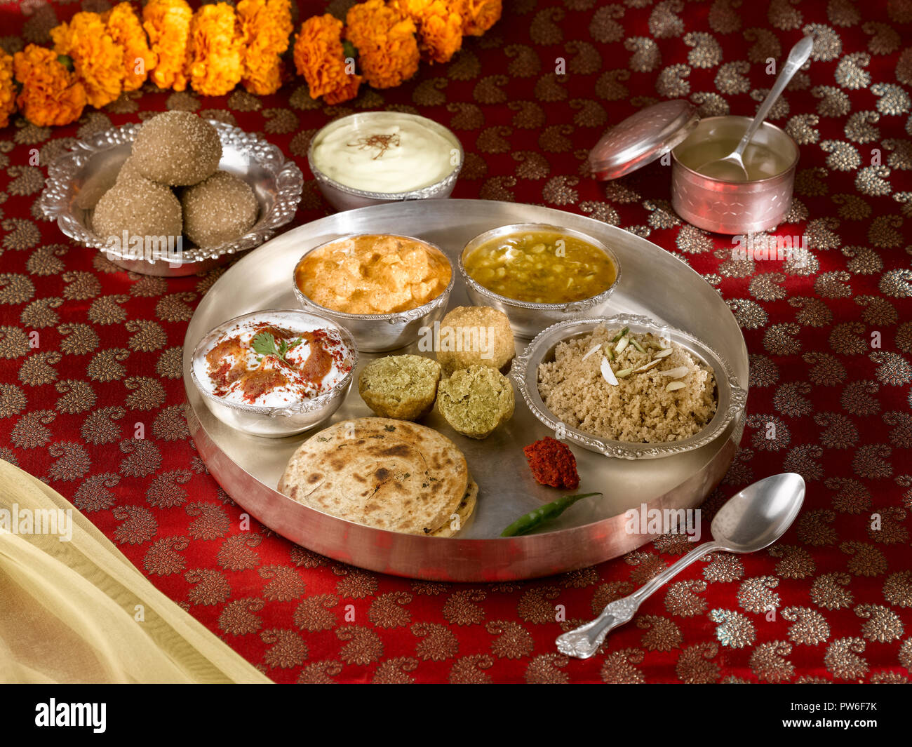 Un plein repas/ TRADITIONNELLE RÂJASTHÂNÎ THALI RAJASTHANI : DE GAUCHE À DROITE : CHURMA KE LADOO, SHRIKHAND,GHEE, CHURMA, chutney, vert d'AIL FRAIS, LE METHI BHAK Banque D'Images