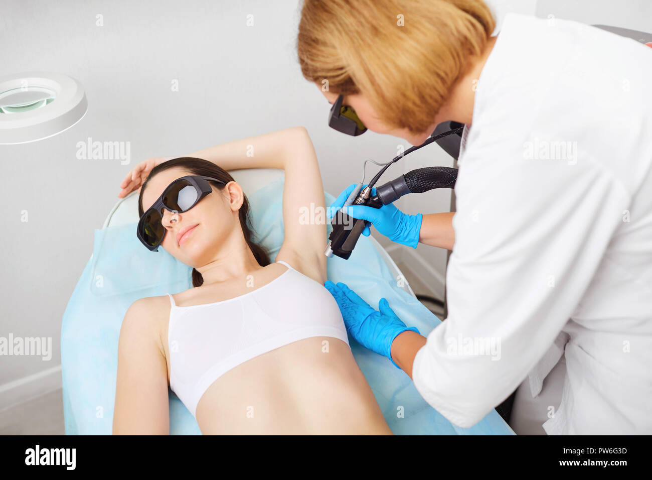 L'enlèvement de cheveux de laser sous le bras d'une jeune femme dans un cosmetolo Banque D'Images