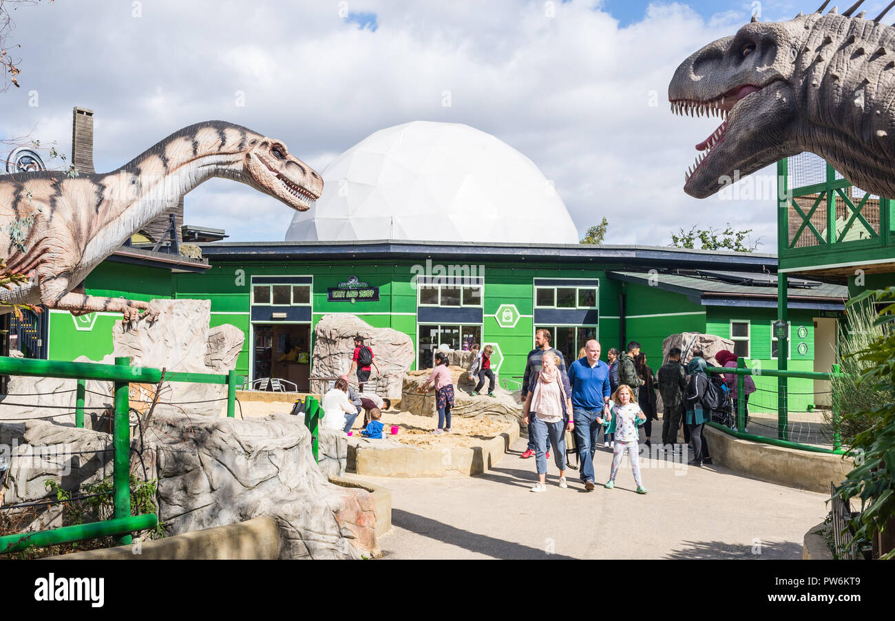 Gulliver's Dinosaur & Farm Park, Monde perdu - Milton Keynes, Royaume-Uni. Entrée du parc avec les visiteurs et les grands dinosaures répliques Banque D'Images