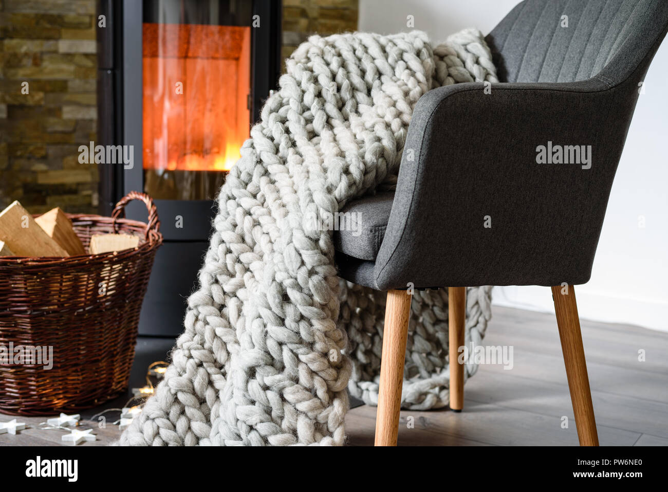 Ein Sessel im Wohnzimmer vorm Kamin.Holz. Banque D'Images