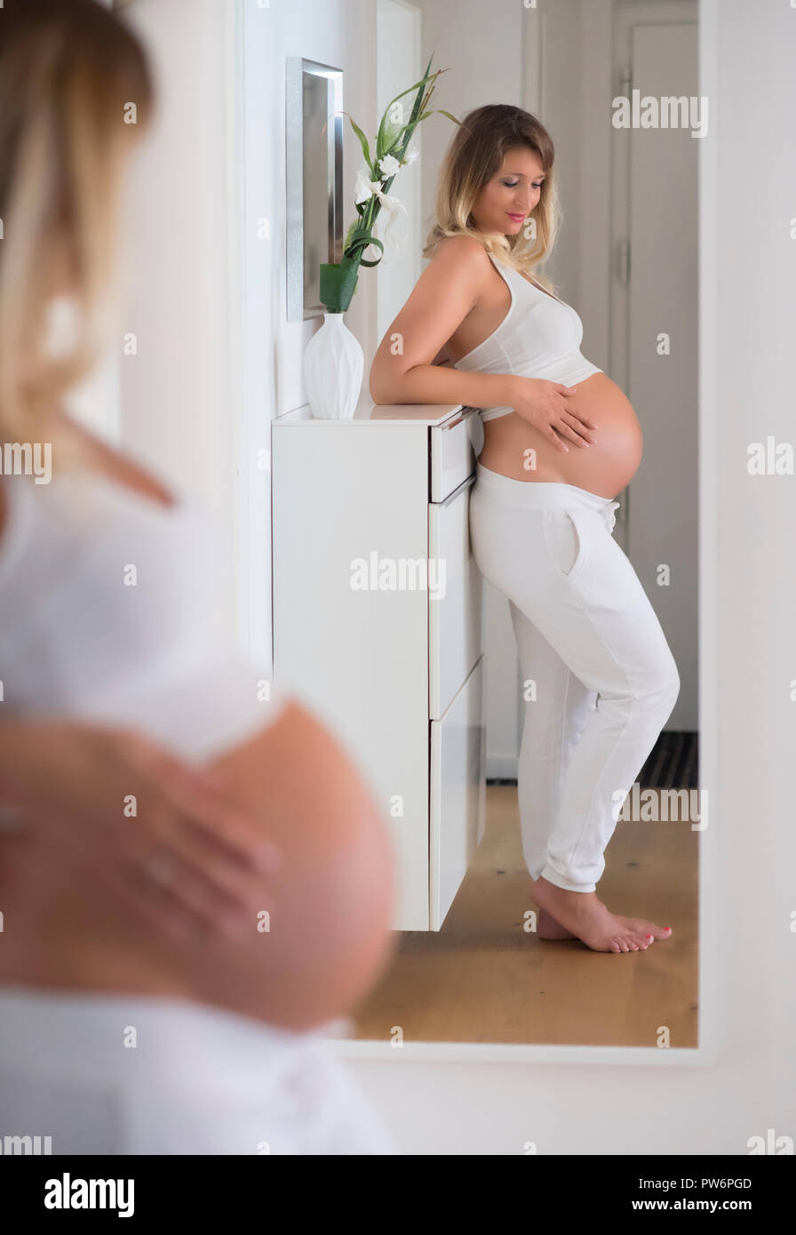 Femme dans son neuvième mois de grossesse, se regarde dans le miroir, Allemagne Banque D'Images