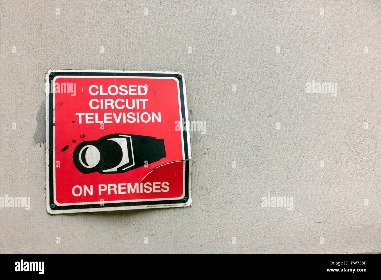 Rugueux ciment mur texturé avec du rouge noir blanc craquelé ancien avertissement signe de la télévision en circuit fermé sur place icône Caméra vidéo Banque D'Images