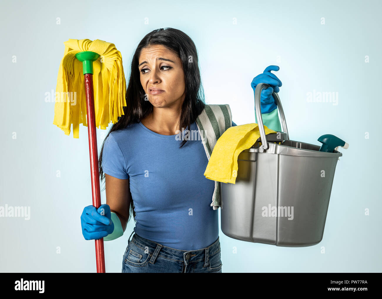 Belle jeune femme au foyer en colère et bouleversé woman holding spray de nettoyage seau mop triste sentiment frustré et paresseux dans les charges domestiques isolés concept Banque D'Images