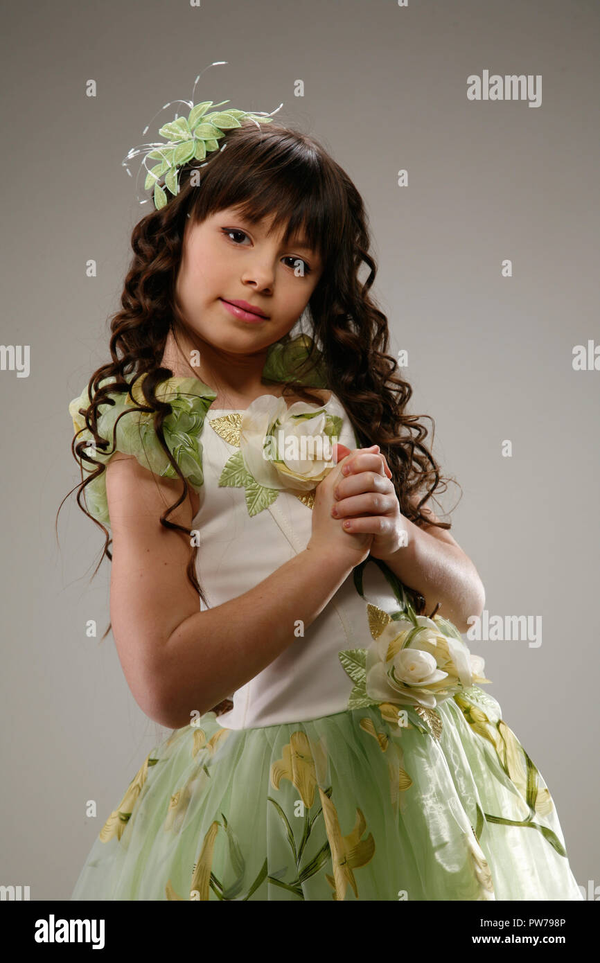 Cute young girl with long hair en robe. Studio toujours sur fond blanc. La princesse blanche posing in studio en mouvement avec des gestes et des différents m Banque D'Images