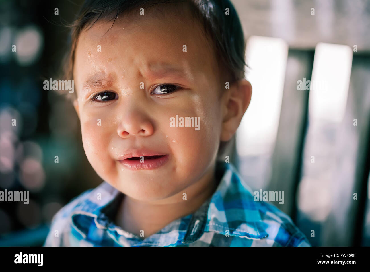 Jeune fils, enfant en âge de pleurer avec des larmes dans les yeux à la perte ou de l'inquiétude à l'arrière-plan, l'expression menaçante ou blesser les enfants disparus Banque D'Images