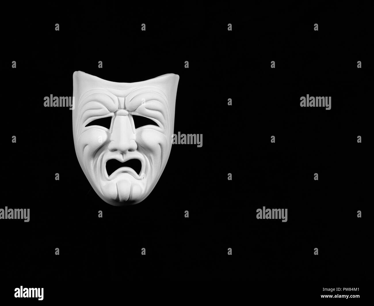 Masque de théâtre expresing la tragédie, masque blanc sur fond noir avec de l'espace libre pour le texte Banque D'Images