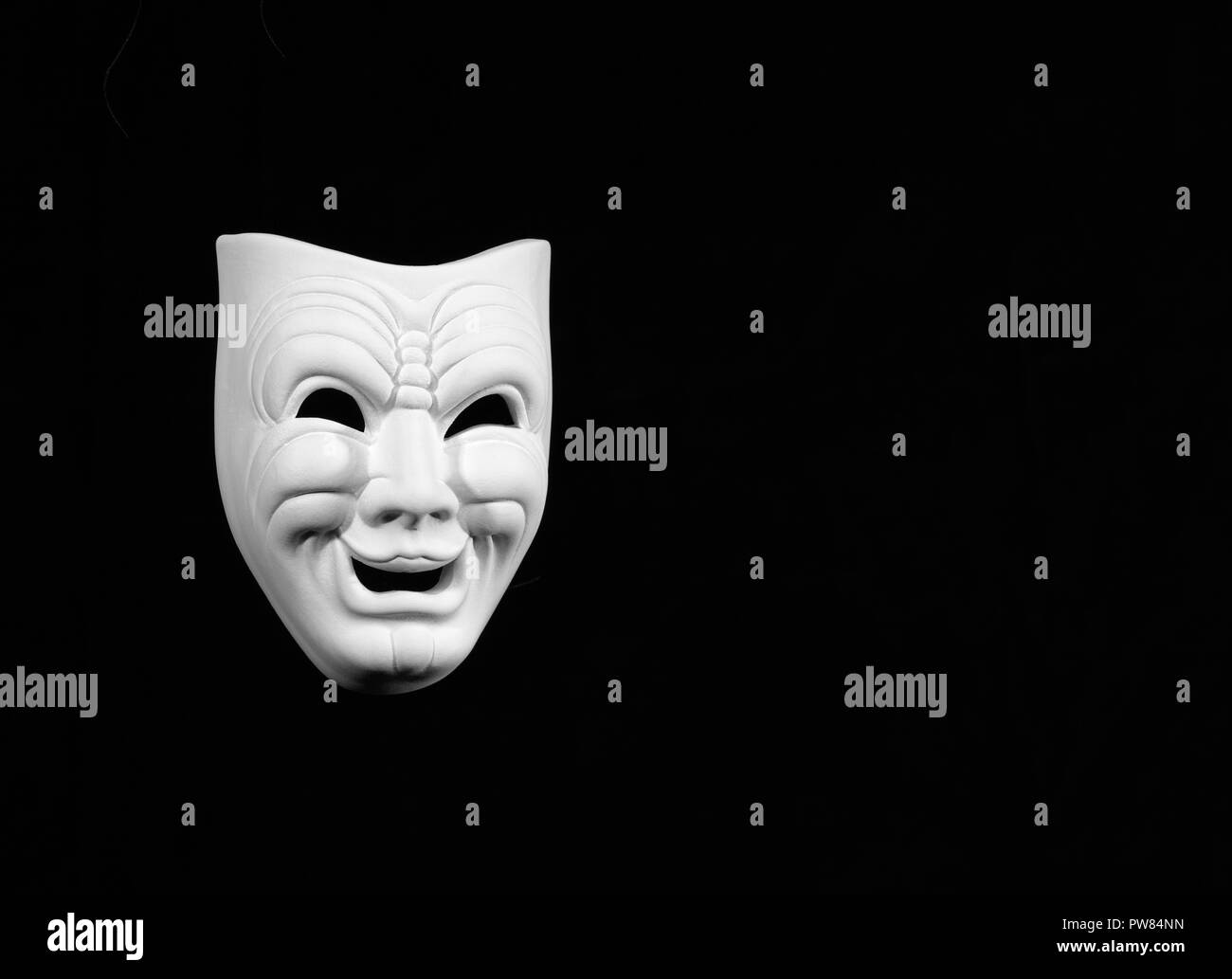 Masque de théâtre le expresing comédie, masque blanc sur fond noir avec de l'espace libre pour le texte Banque D'Images