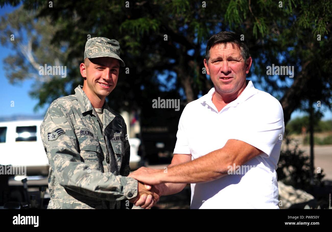Les cadres supérieurs de l'US Air Force Airman Keith Buckman, 923rd e Escadron de maintenance technicien propulsion aérospatiale, et Mark Byrne (57 ans), vétéran de l'armée, de partager une poignée à la base aérienne Davis-Monthan Air Force Base, en Arizona, le 2 octobre 2017. Buckman est venu à Byrne's aid au milieu de la nuit et a contribué à lui apporter l'attention médicale dont il avait besoin lors d'un accident ischémique transitoire. Banque D'Images