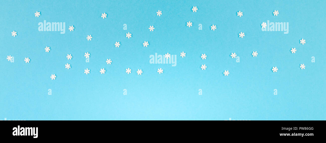 Vue de dessus de la création d'hiver. châssis mise à plat Motif d'hiver Concept petits flocons blancs sur fond bleu pastel copie espace modèle minimalisme anni Banque D'Images