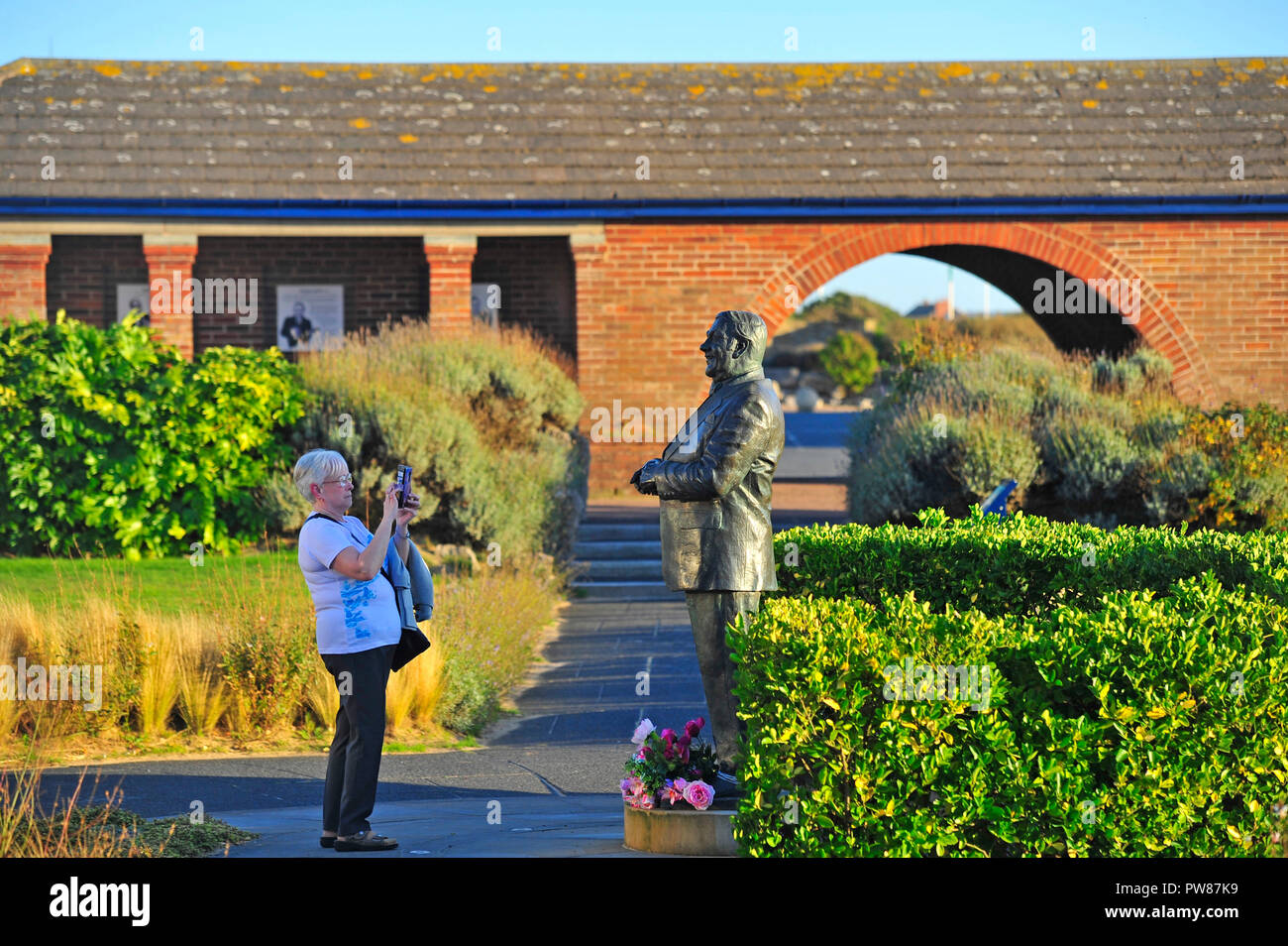 Les femmes prenant des photo de la statue de comédien britannique Les Dawson dans la paix et le bonheur dans le jardin St Annes on Sea, Lancashire, Royaume-Uni Banque D'Images